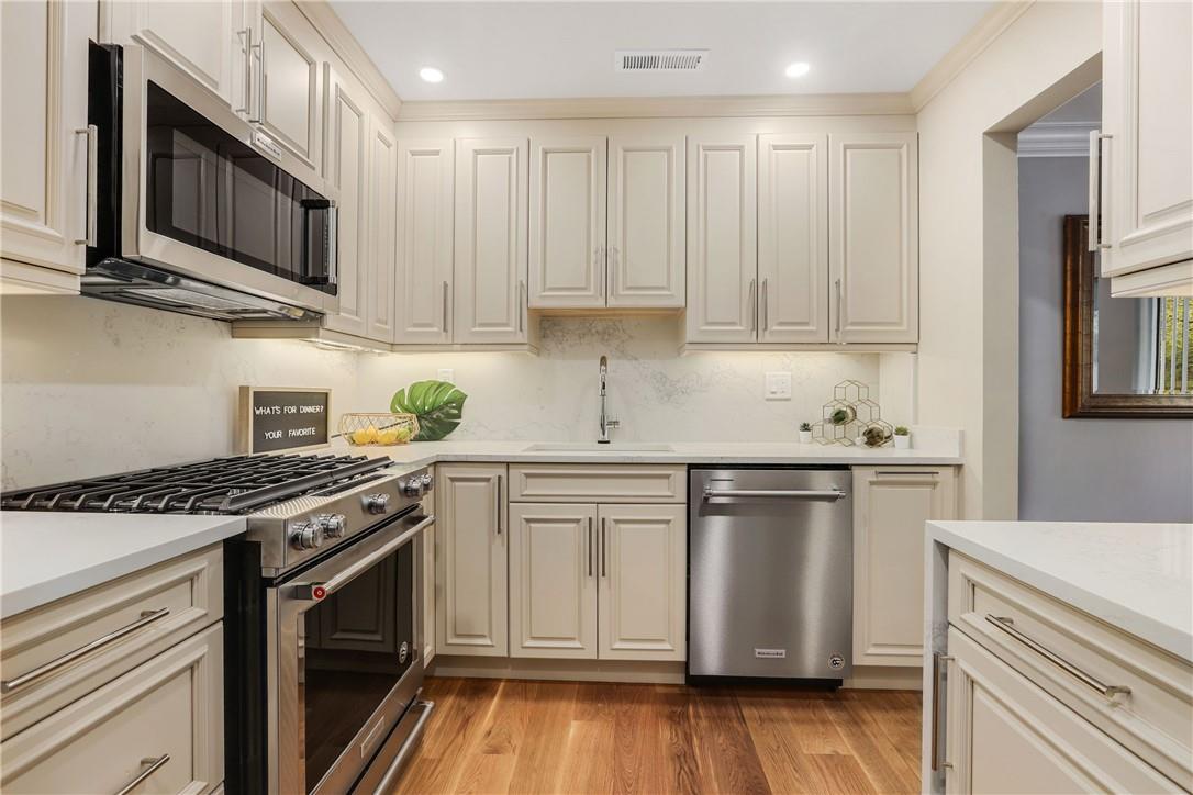 a kitchen with stainless steel appliances granite countertop a stove a sink and a microwave