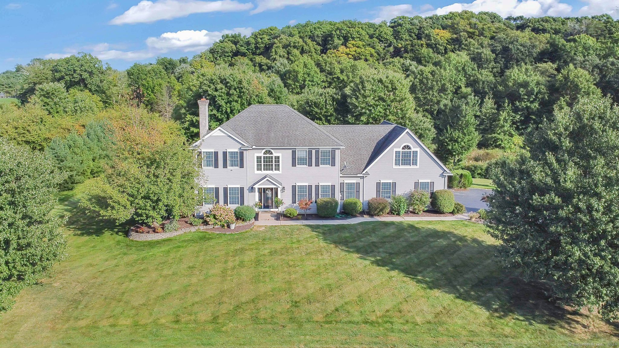 a front view of a house with a yard and trees