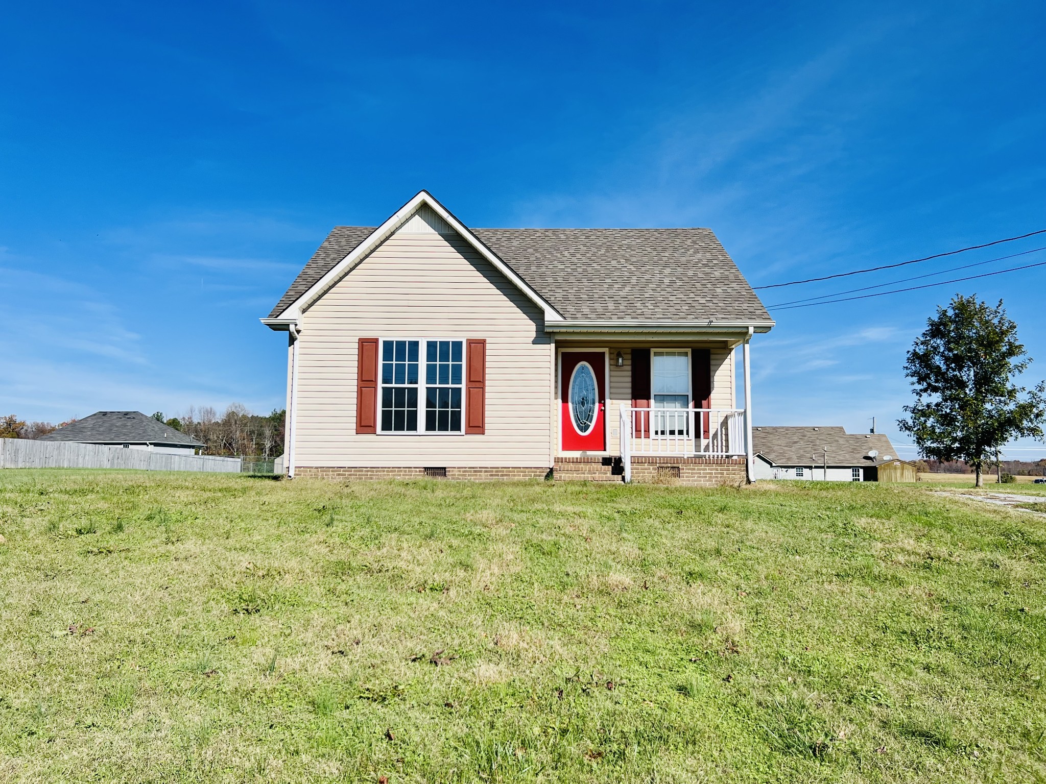 a front view of a house with a yard and trees