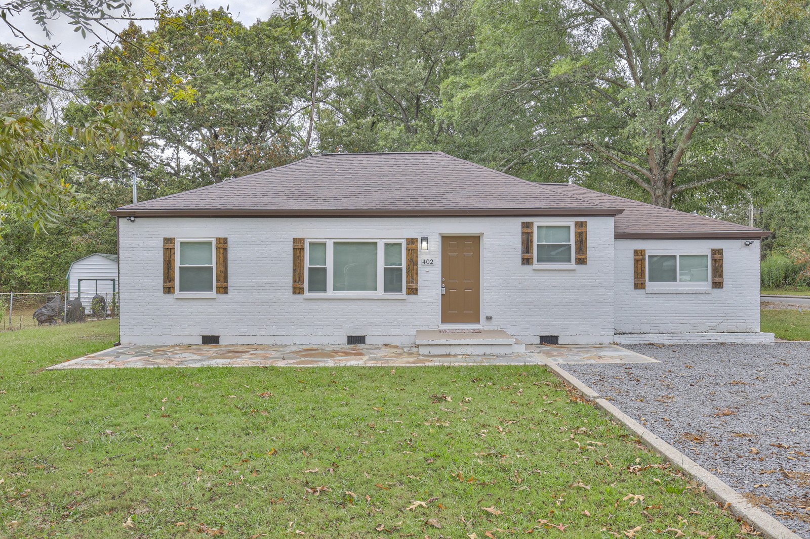 a front view of a house with a yard and trees