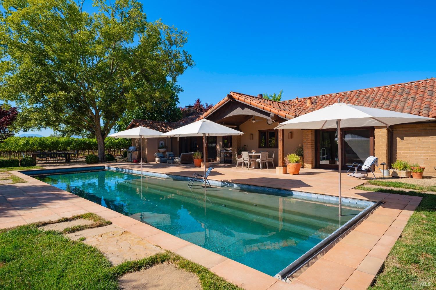 a view of a house with a yard patio and swimming pool