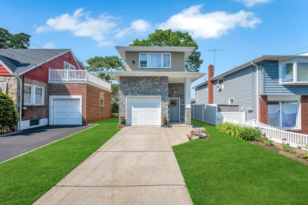 View of front of house with a balcony and a front yard