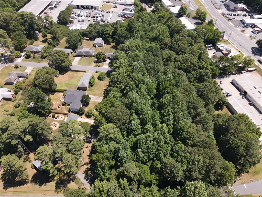 an aerial view of residential houses with outdoor space and trees