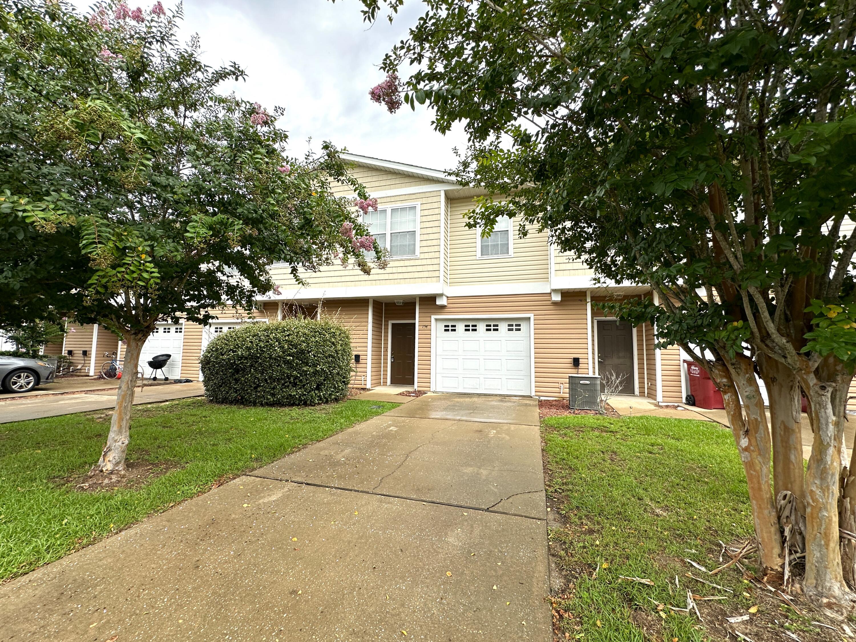 a front view of a house with a yard and trees