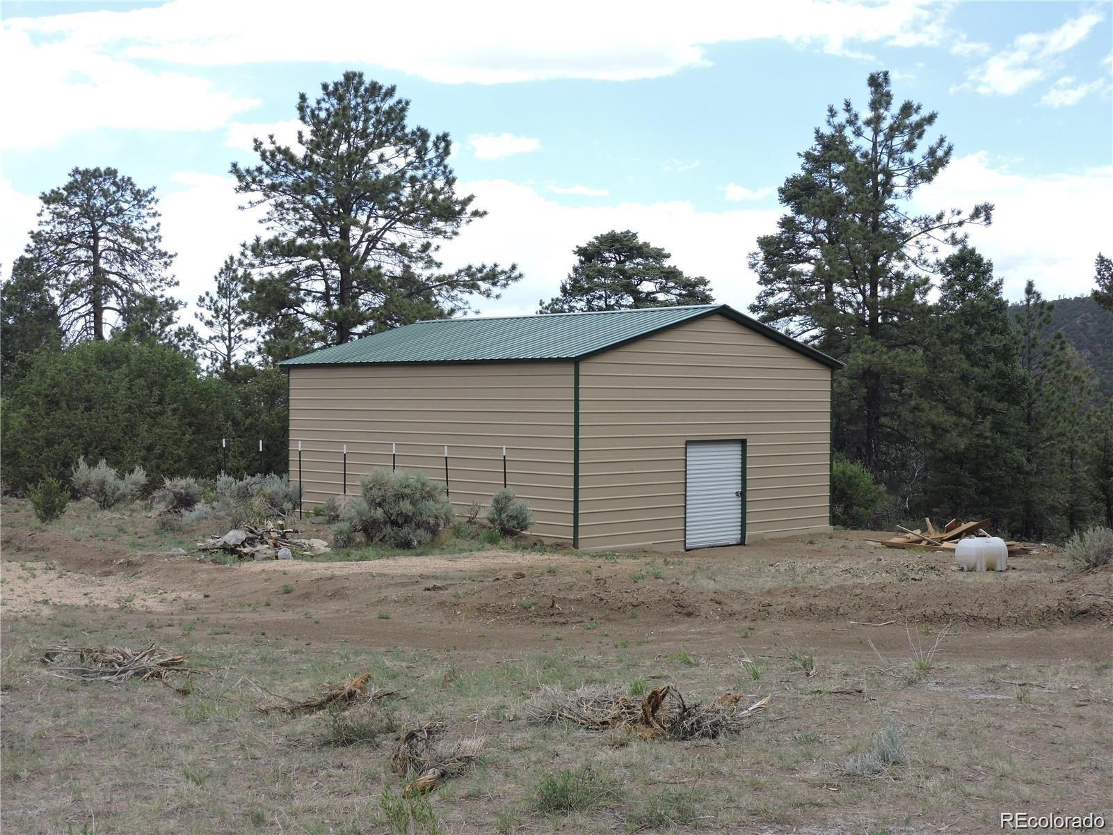 a view of house with yard and trees in the background