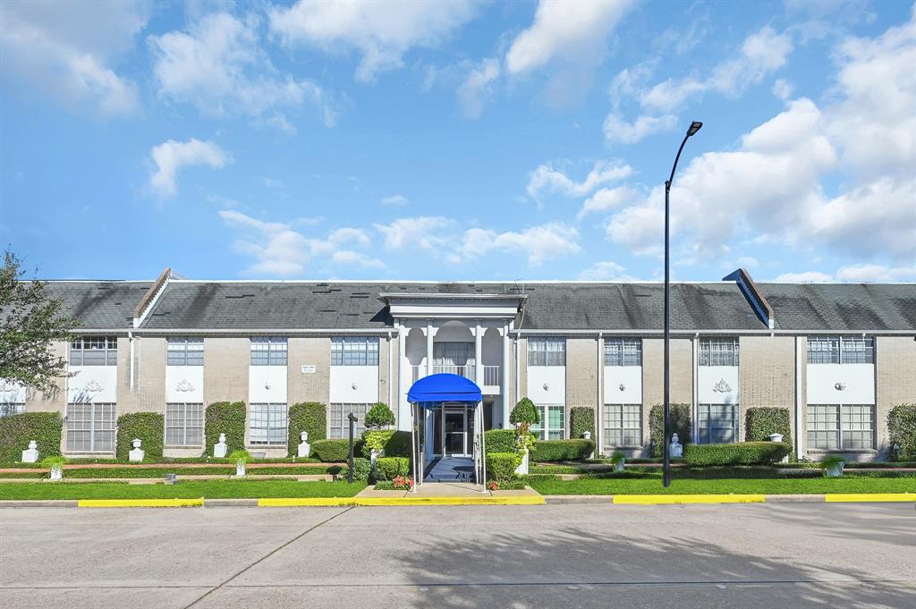 a view of a big building with swimming pool and yard in the back