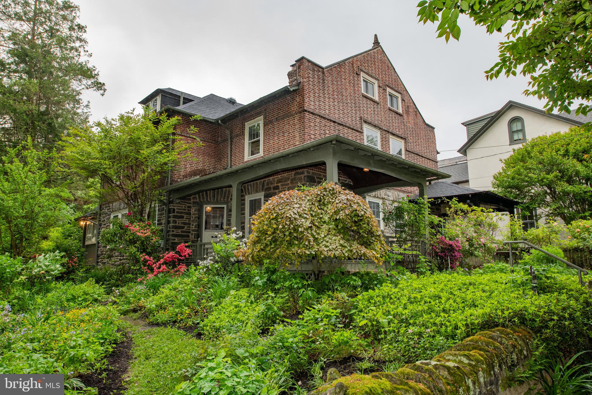 a view of a house with lots of plants and flowers