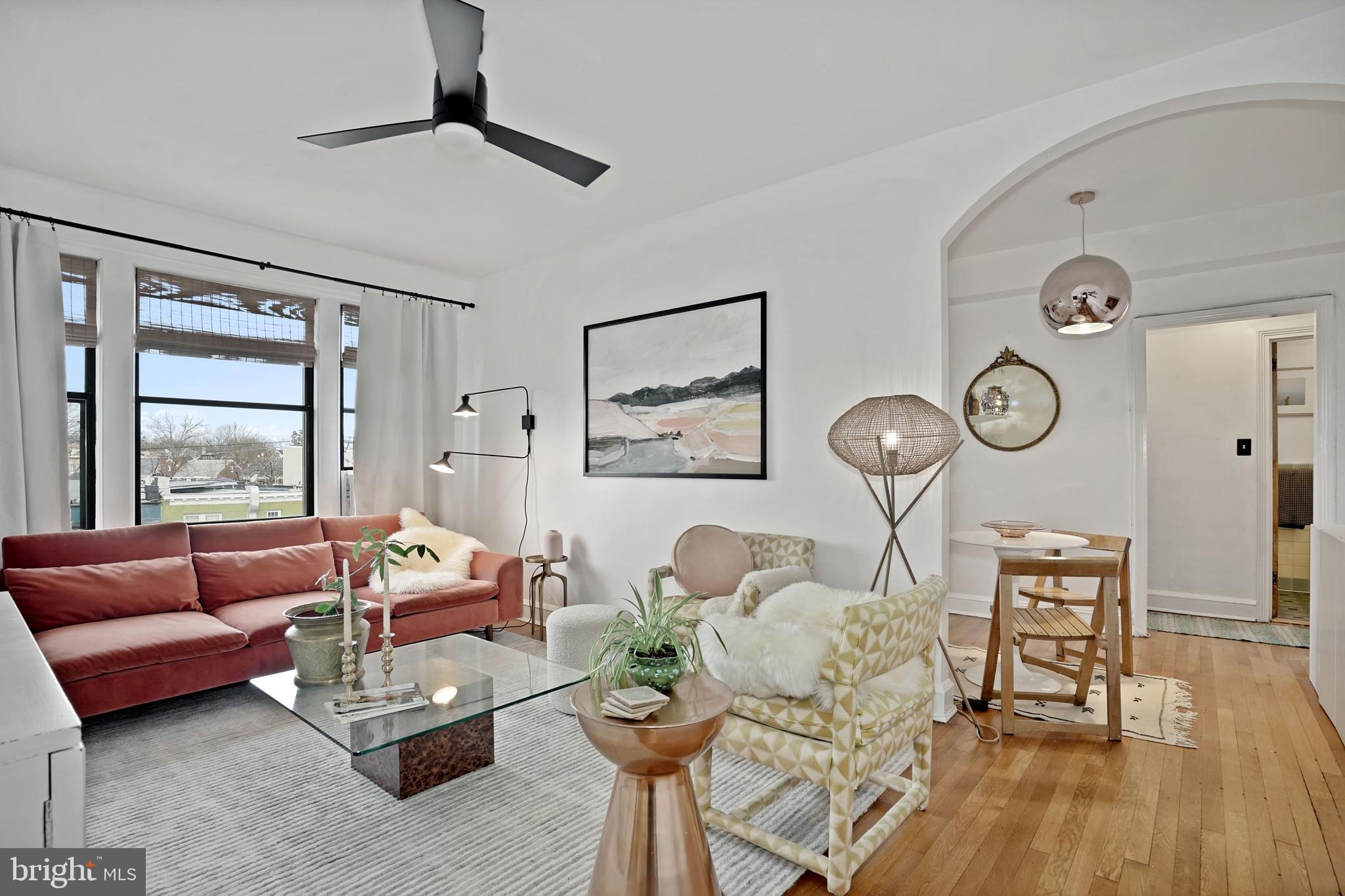 a living room with furniture a rug and a large window