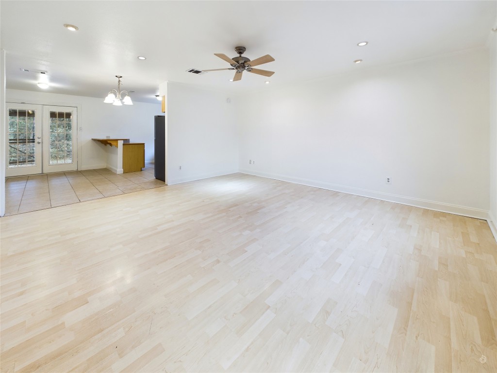 an empty room with a windows and ceiling fan