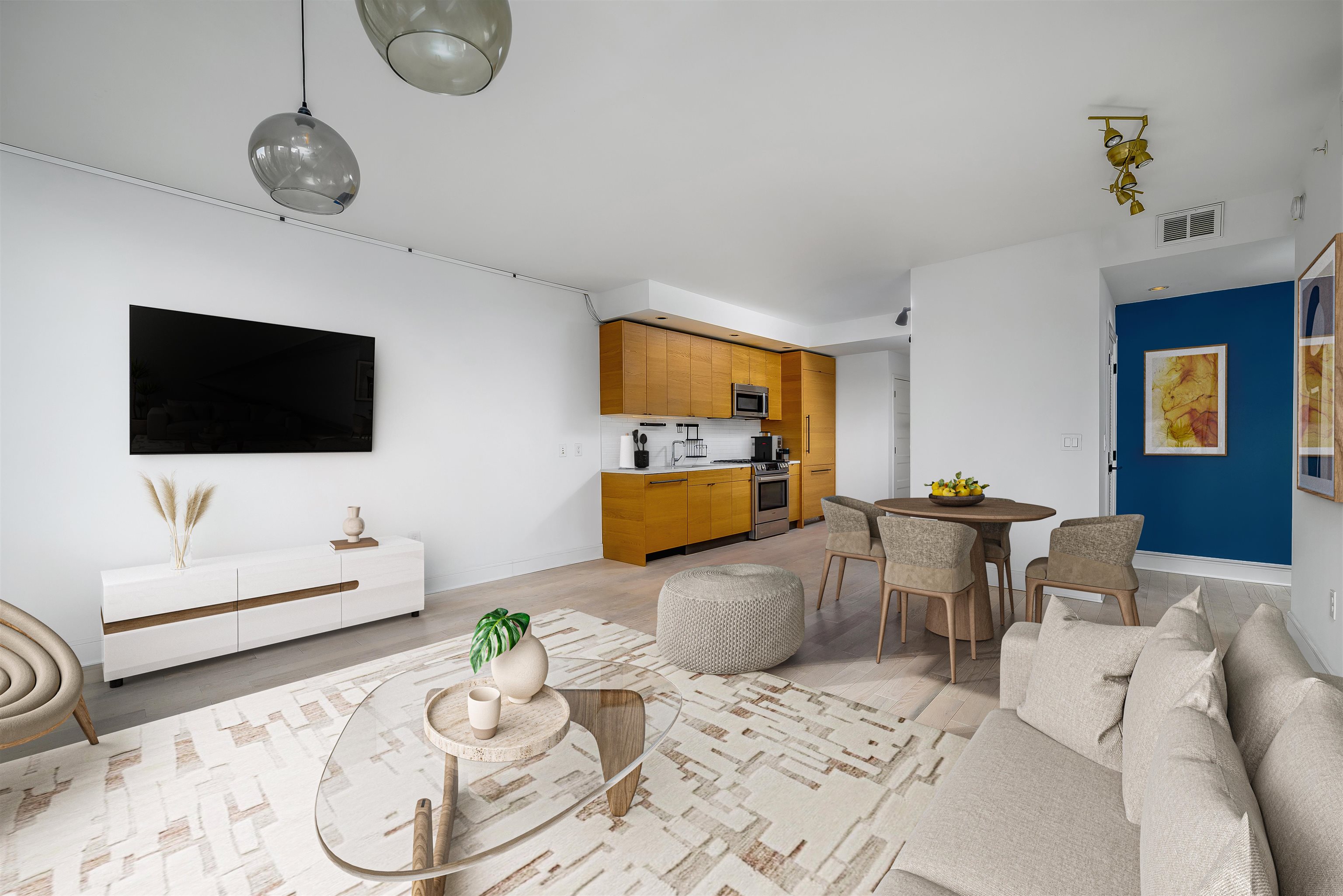 a living room with furniture a flat screen tv and kitchen view