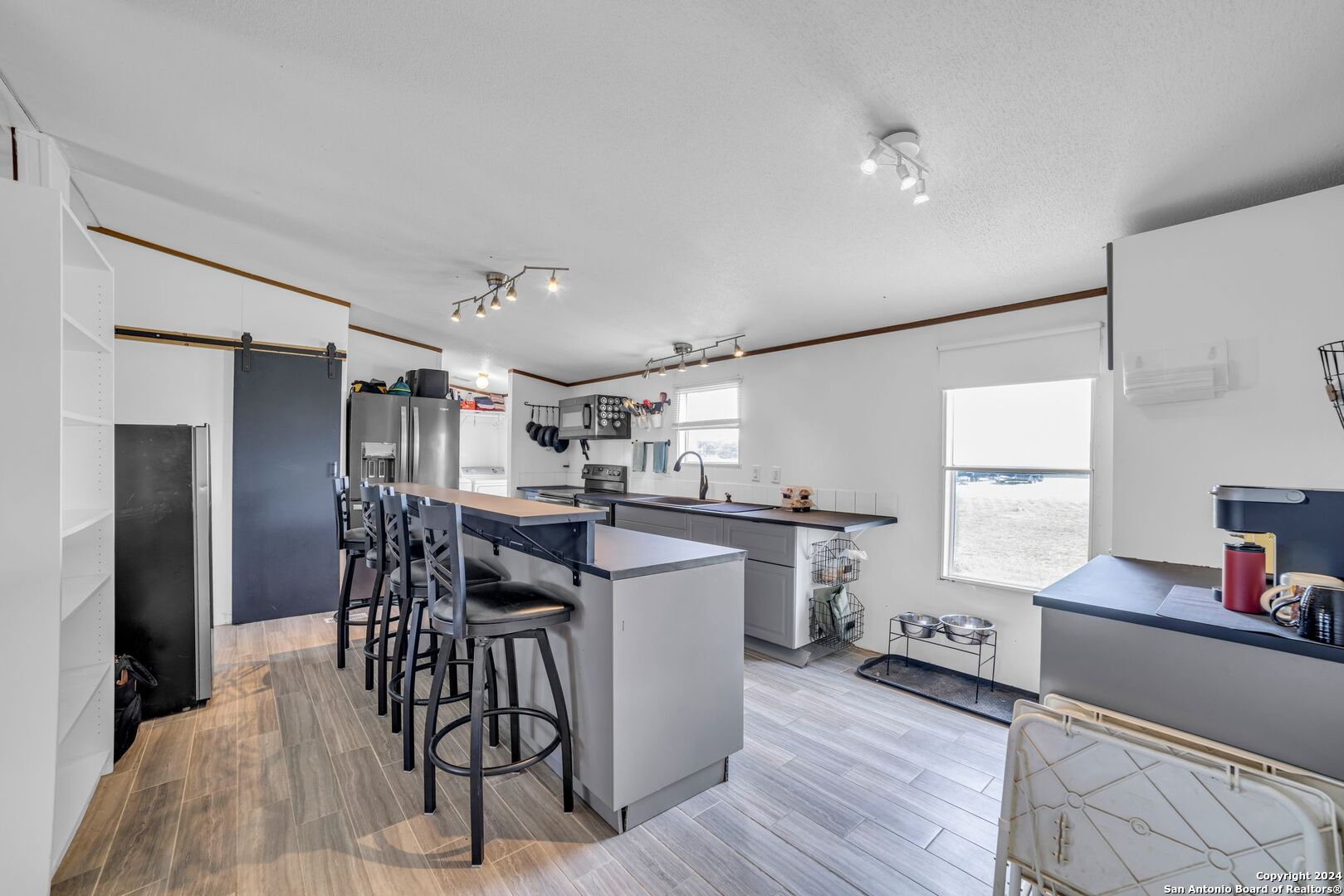 a kitchen with a dining table chairs refrigerator and cabinets