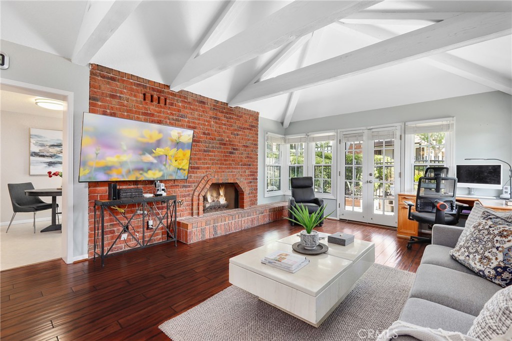 a living room with furniture a fireplace a flat screen tv and a large window