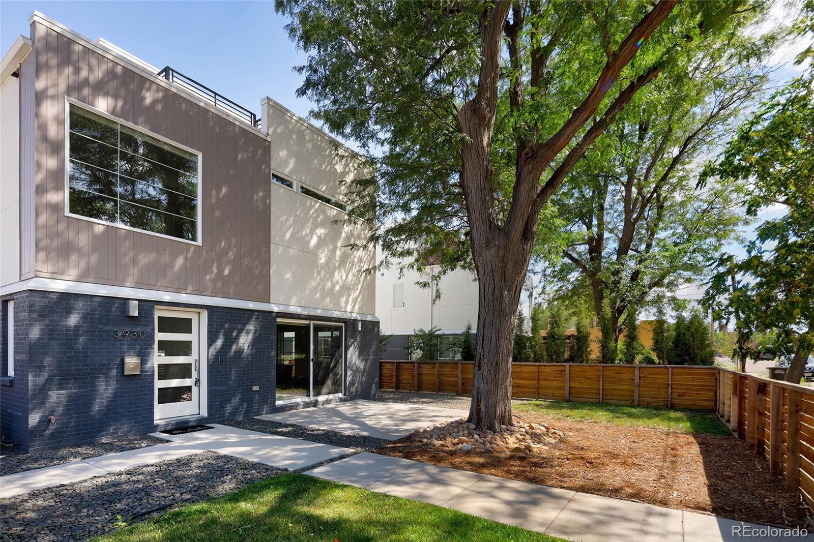 a view of a house with backyard and tree