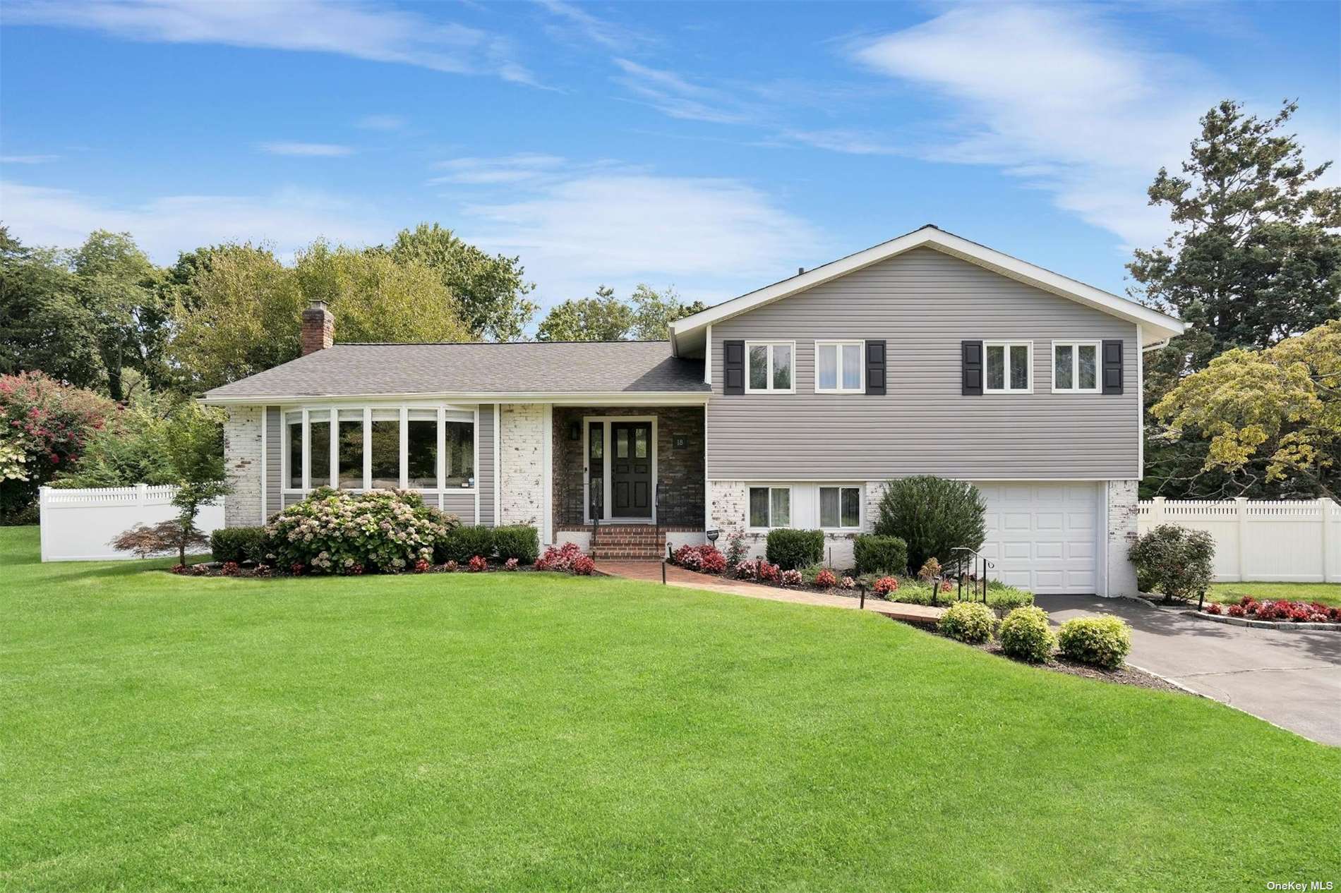 a front view of a house with a garden and yard