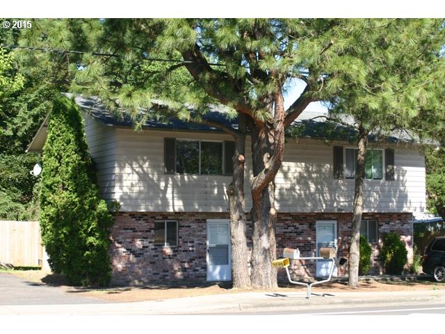 a front view of a house with a tree