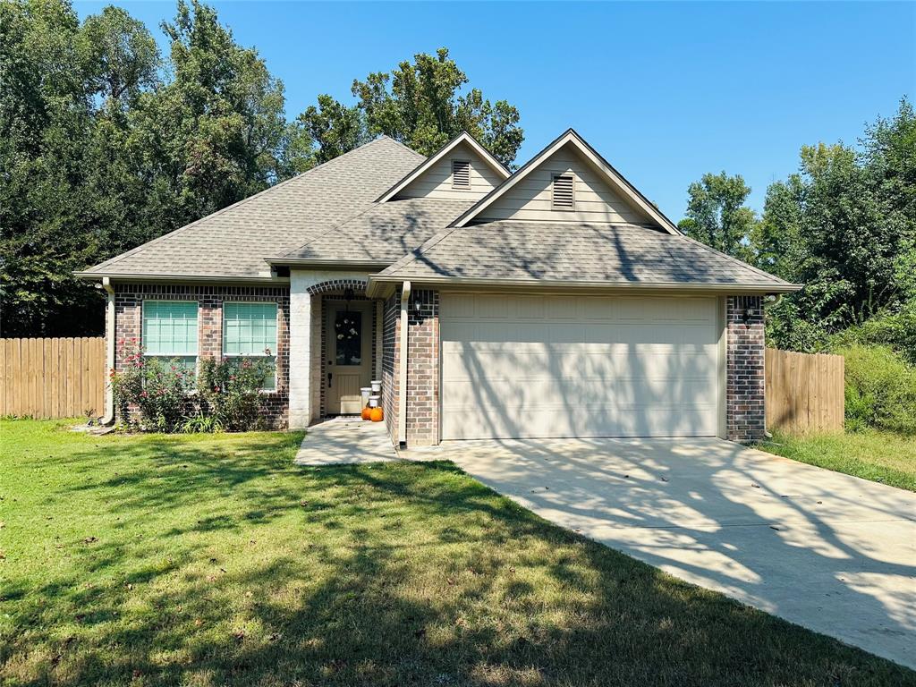 a front view of a house with a garden and yard