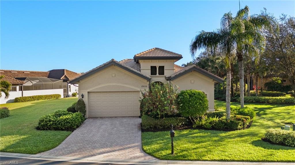 Mediterranean / spanish home featuring a front yard and a garage