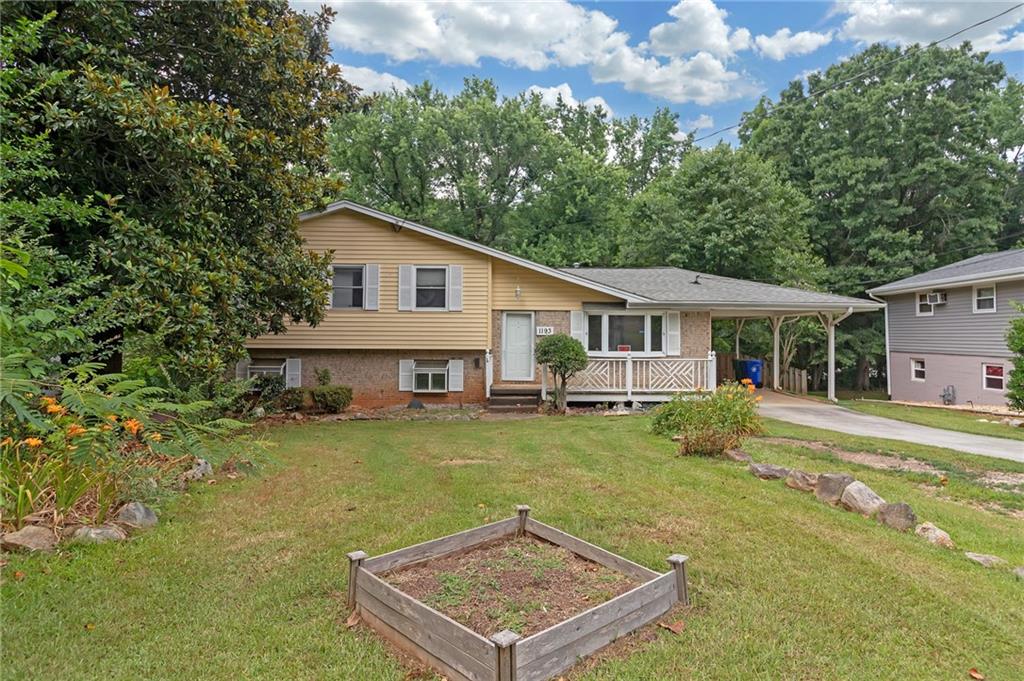 a view of a house with a yard and sitting area