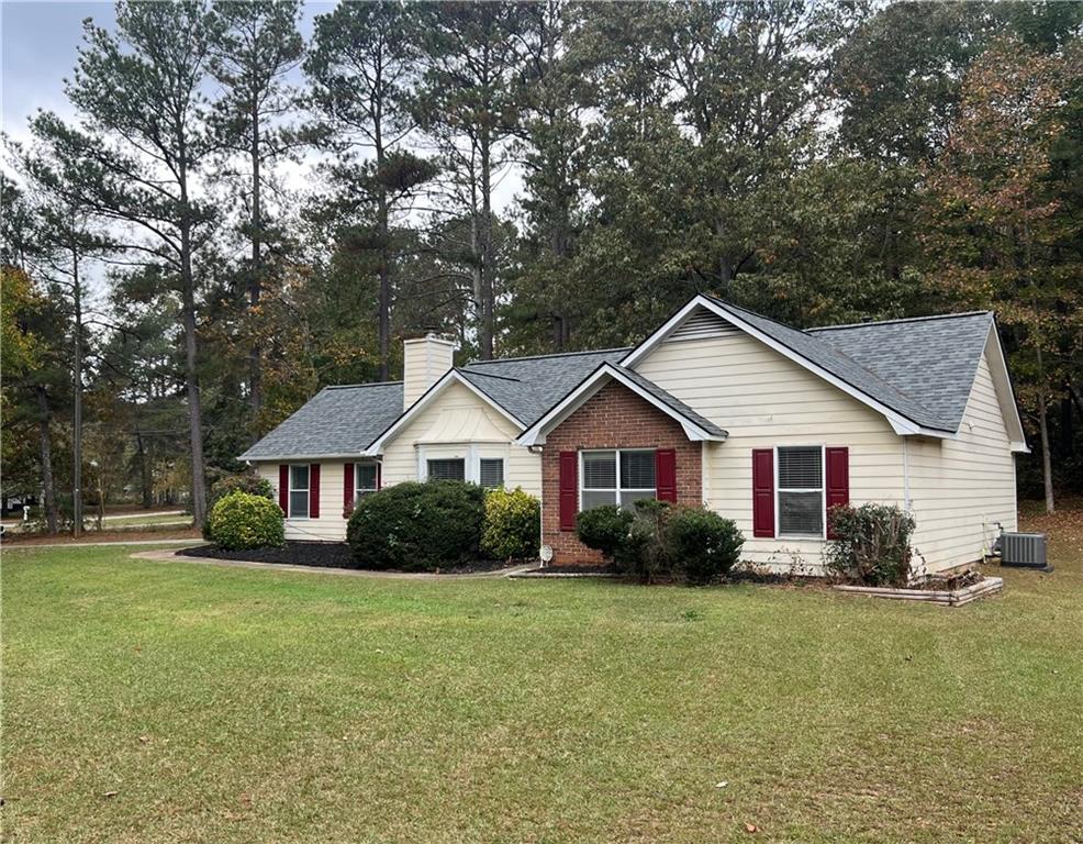 a view of a house with a yard and large trees