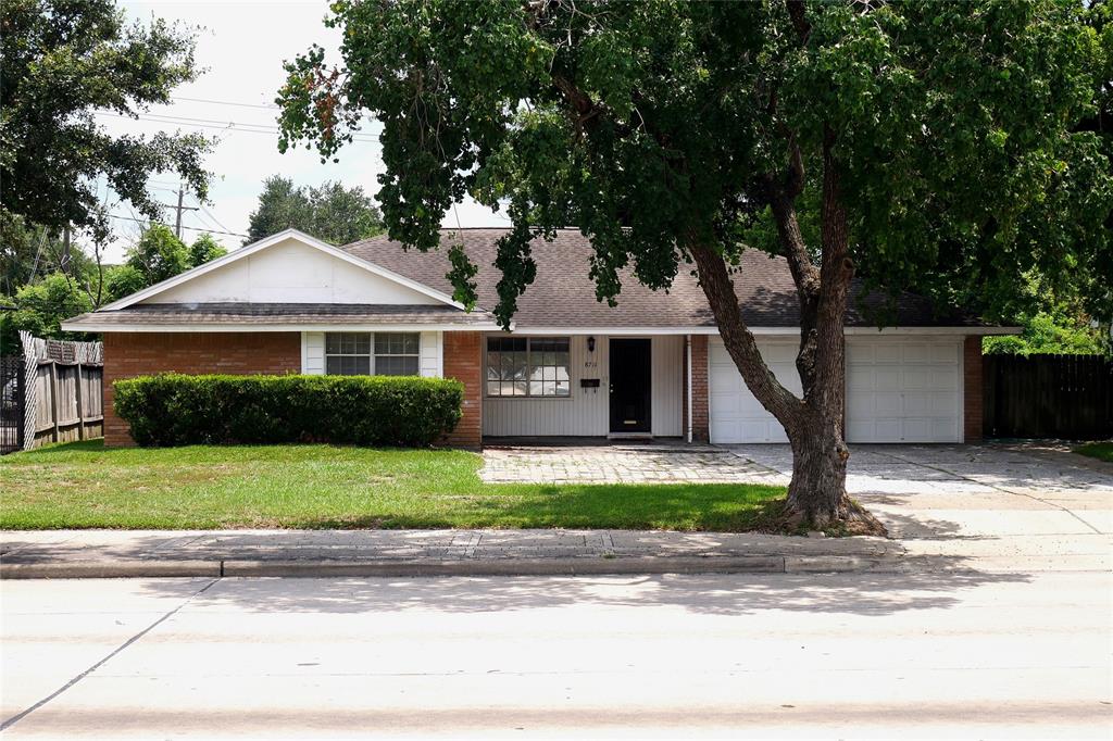 a front view of a house with a garden and trees