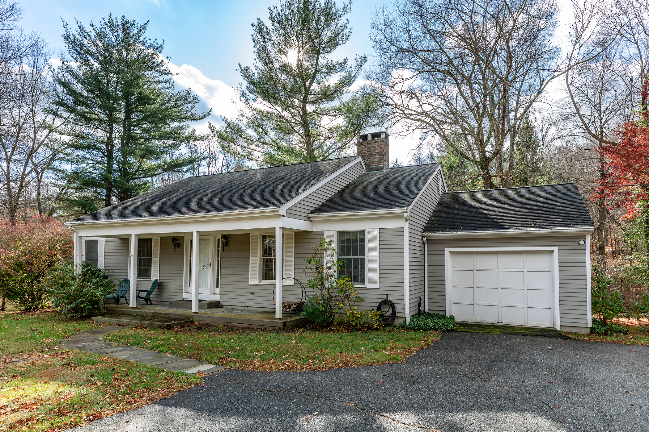 a front view of a house with a garden and trees