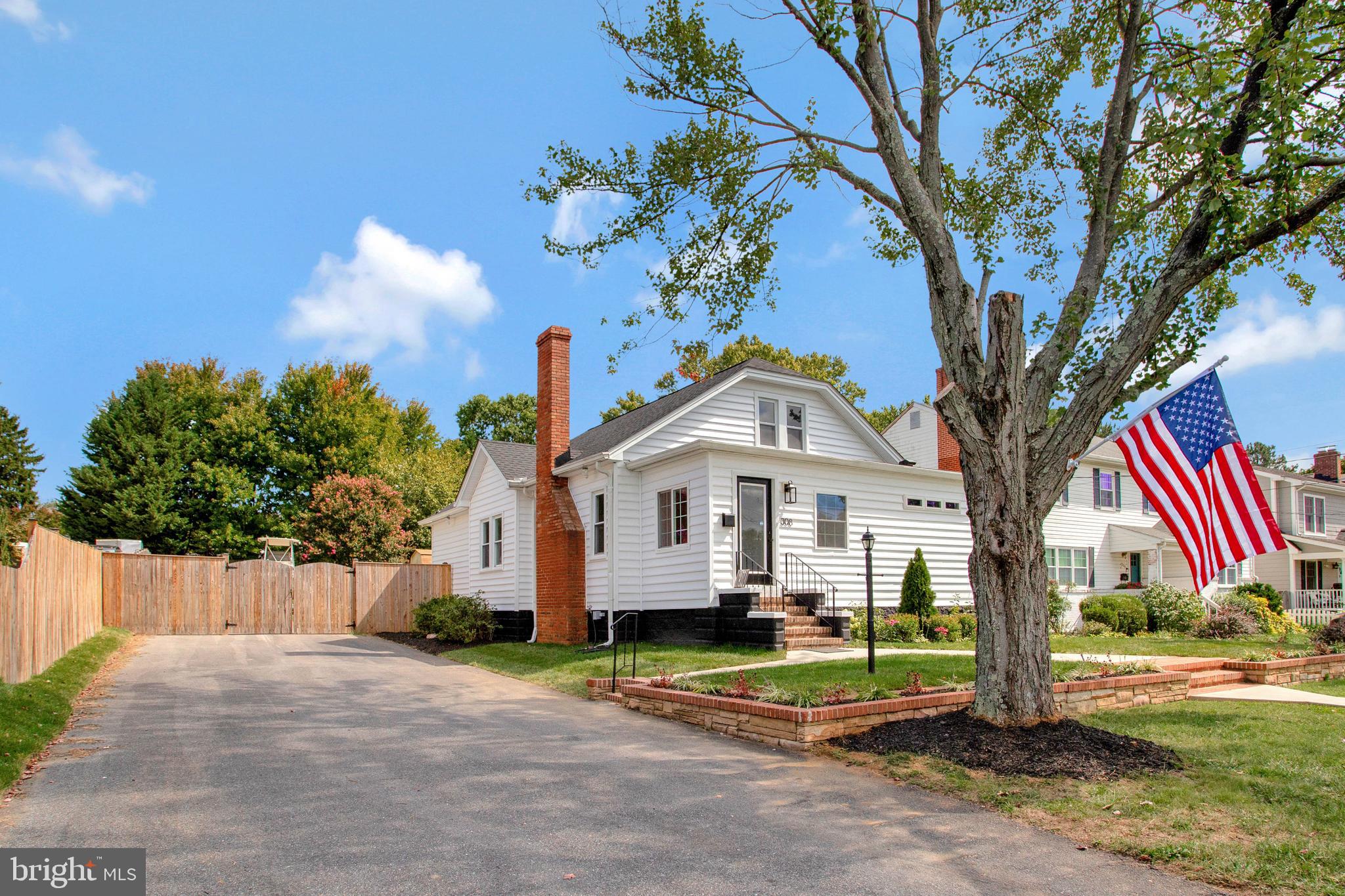 a front view of a house with a garden and trees