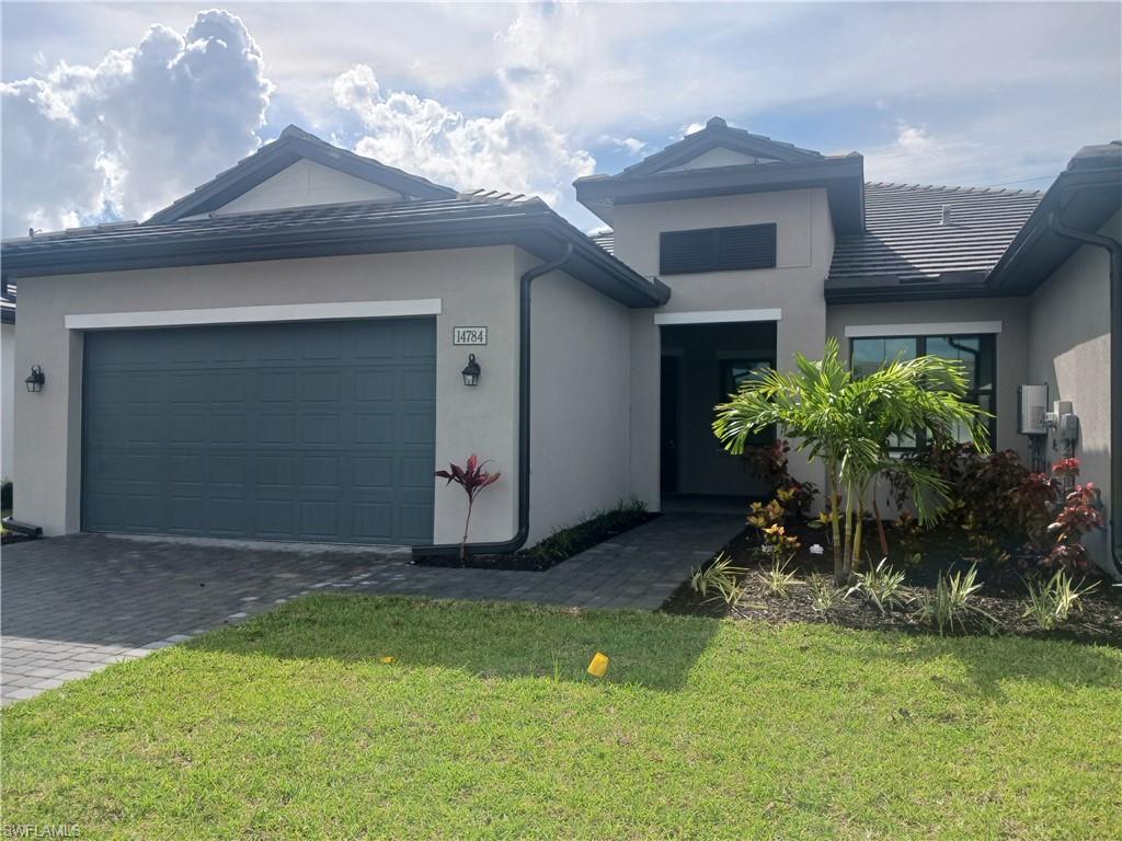 Single story home featuring a garage and a front yard