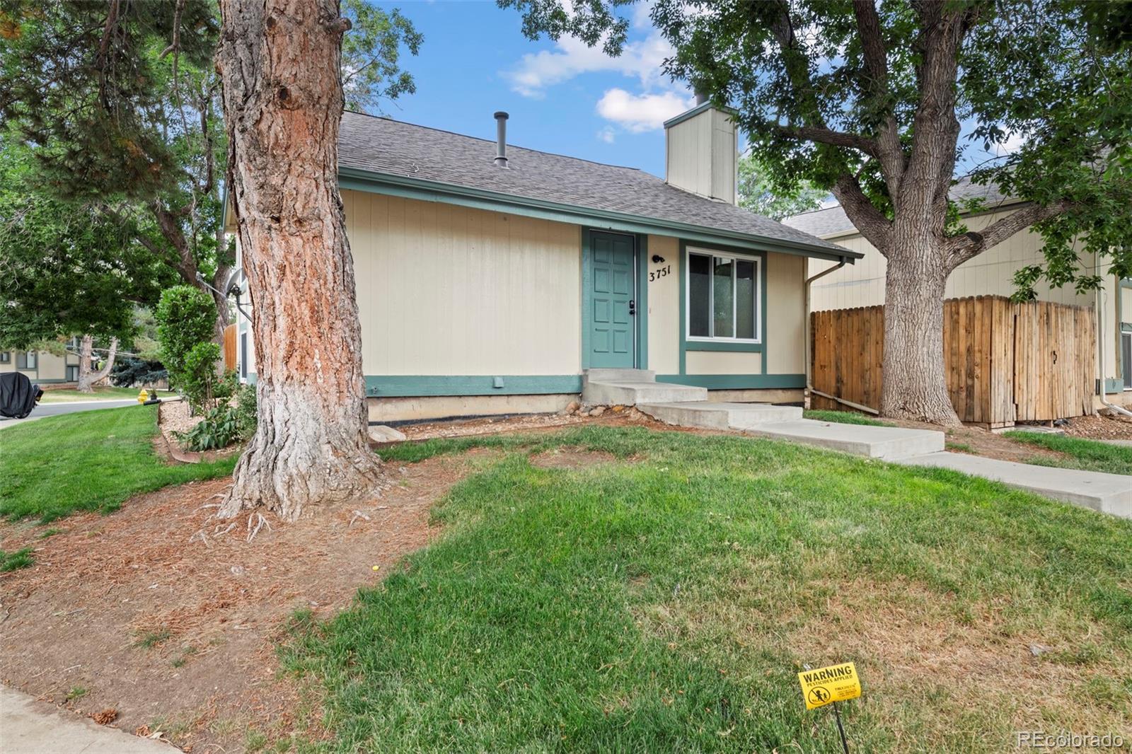 a view of a house with backyard and a tree