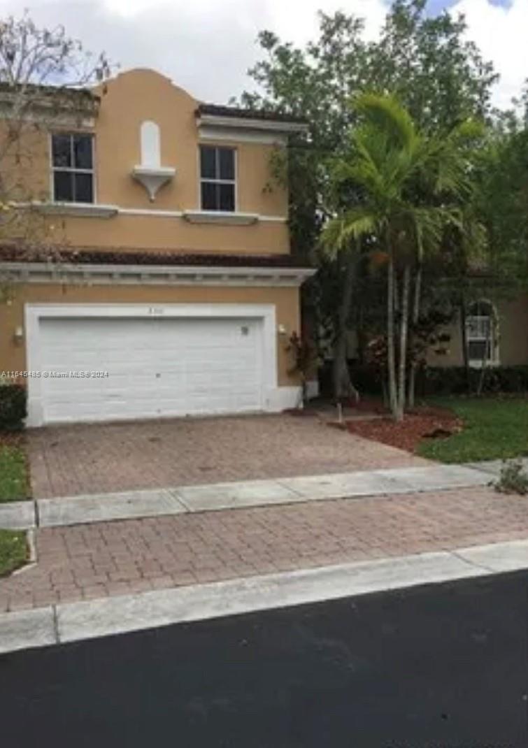 a front view of a house with a yard and garage