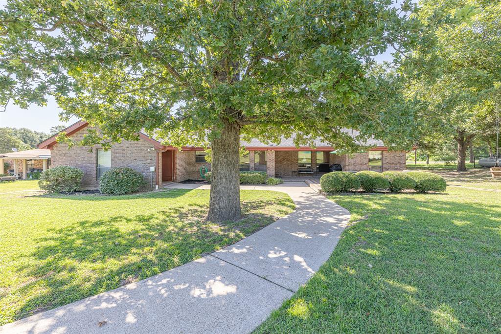 View from the fairway highlighting the shaded backyard and concrete golf-cart path.