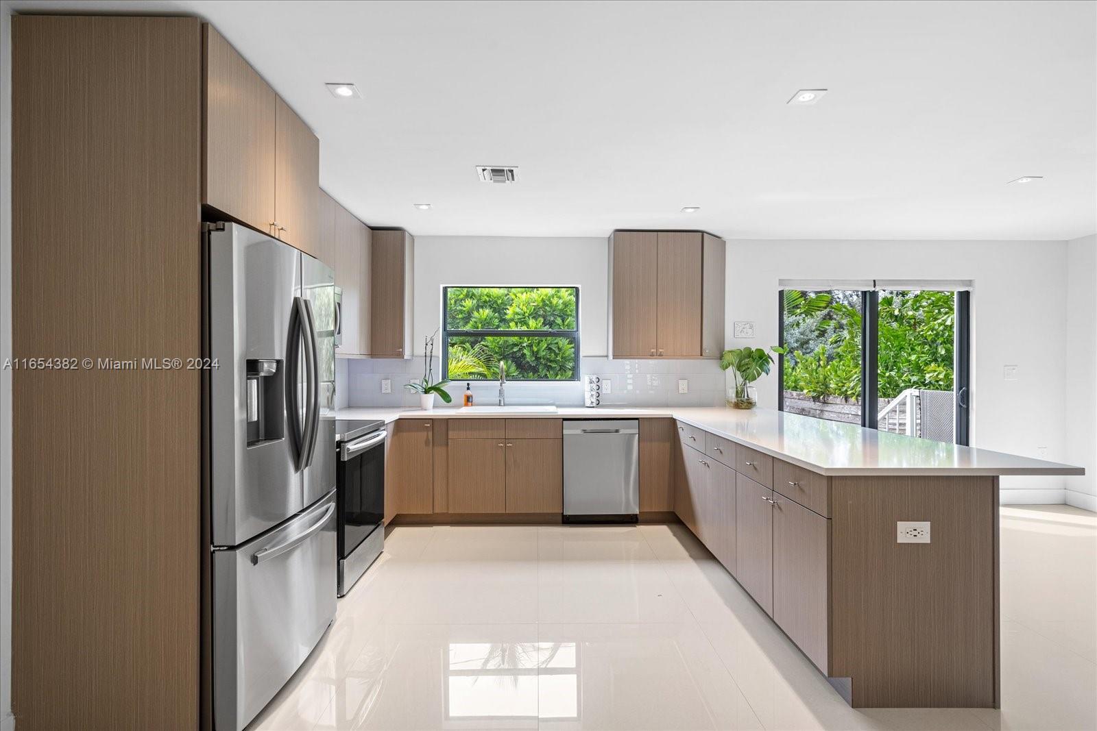 a large kitchen with a window a refrigerator and a sink