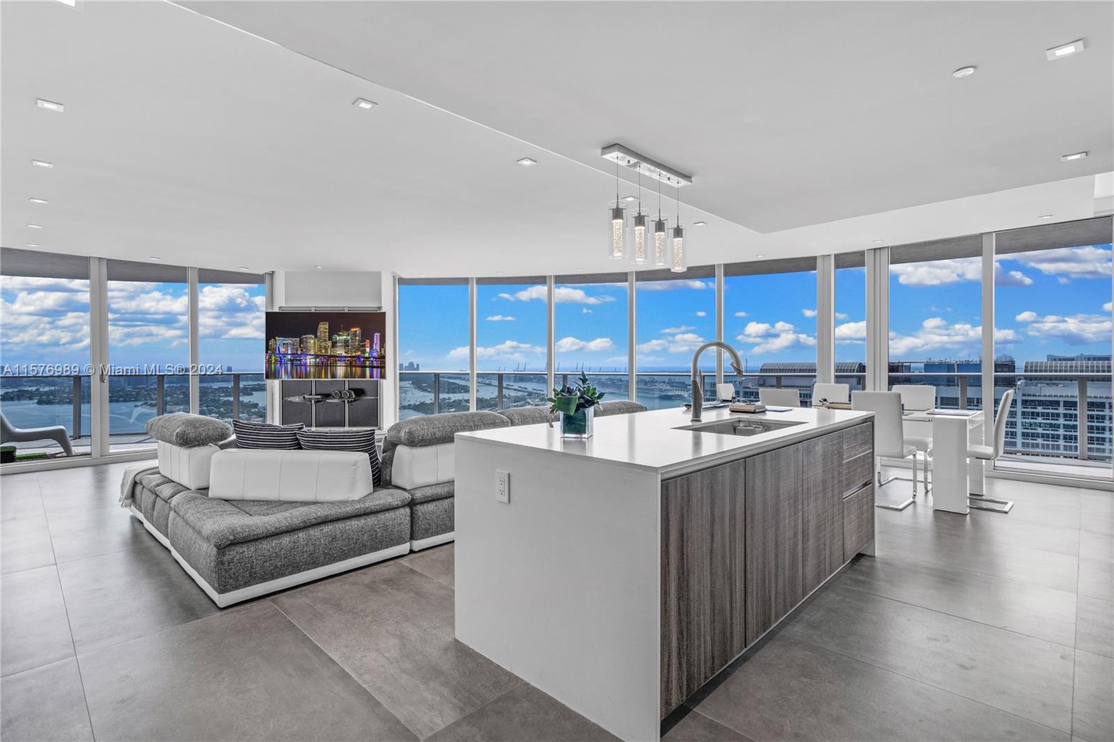 a large living room with kitchen island granite countertop a sink and a large window