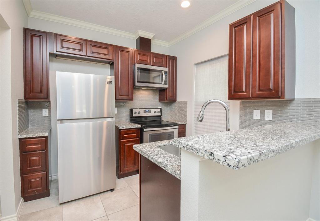 a kitchen with stainless steel appliances granite countertop a refrigerator and a sink