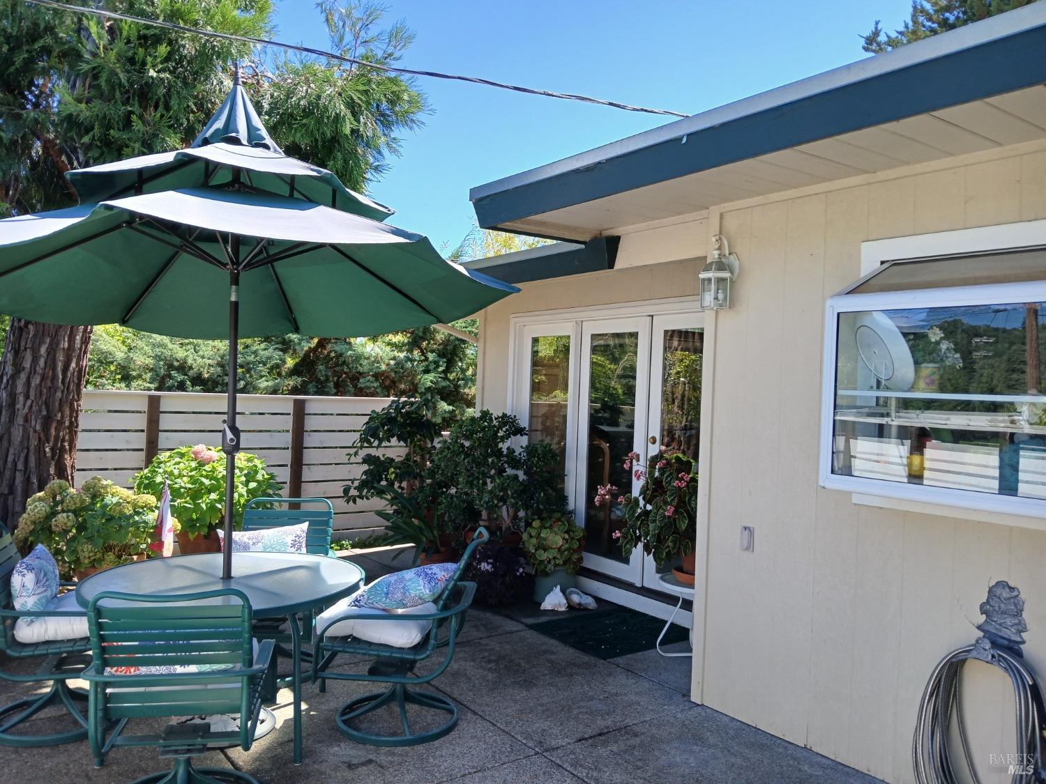 a view of a patio with furniture and a garden