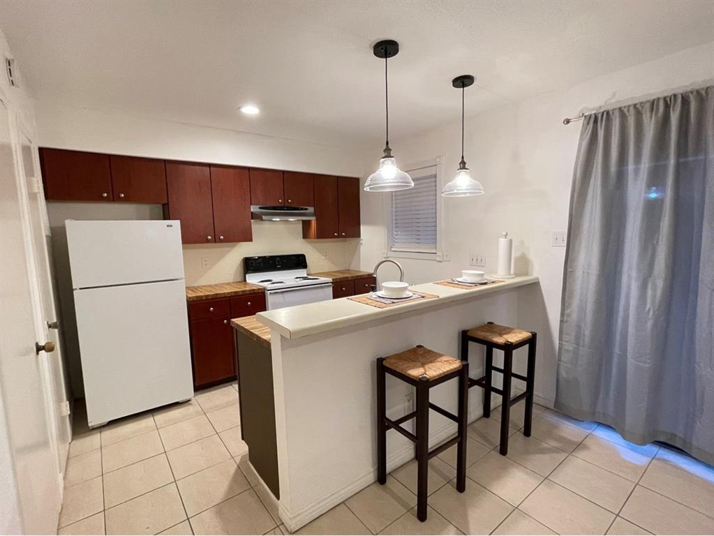 a kitchen with refrigerator and chairs