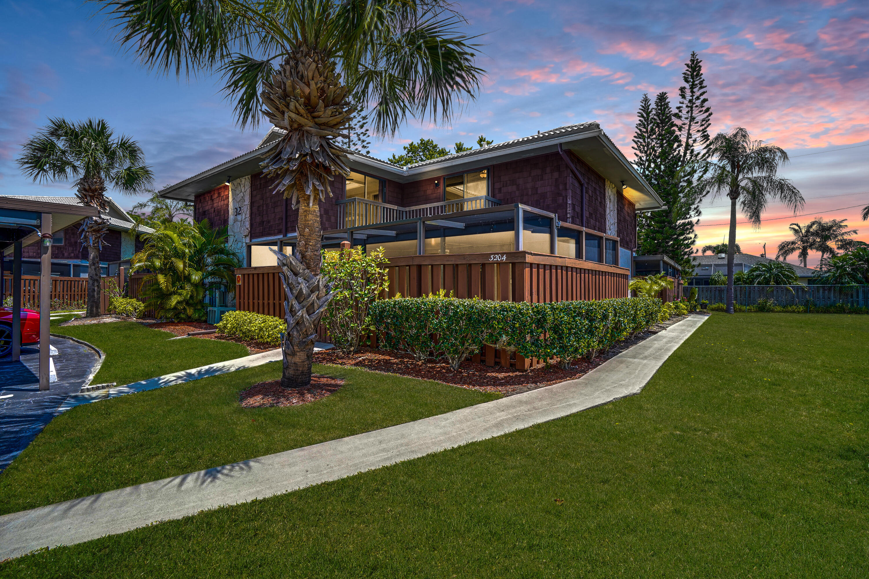 a front view of multi story residential apartment building with yard and green space