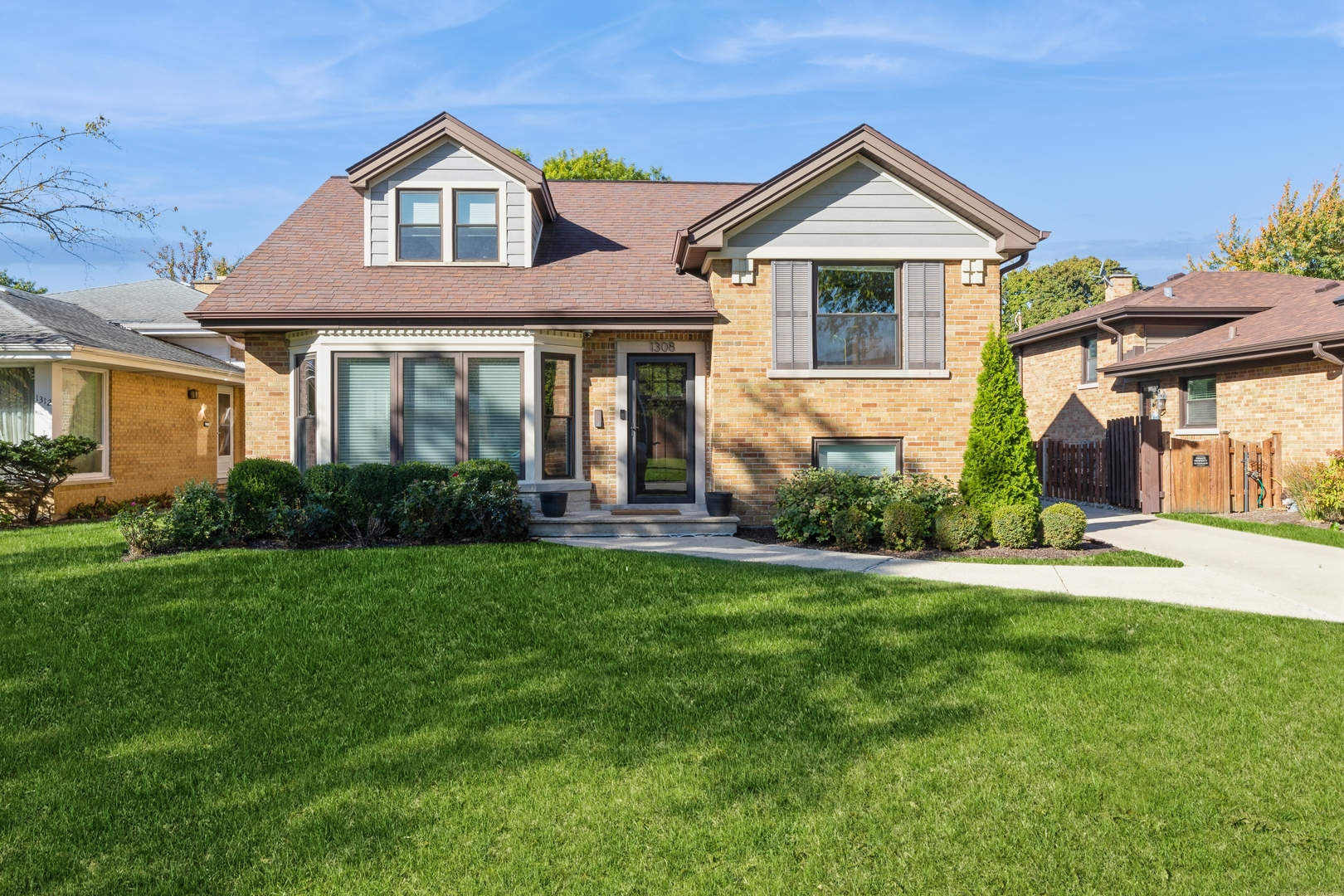 a front view of a house with a yard and green space