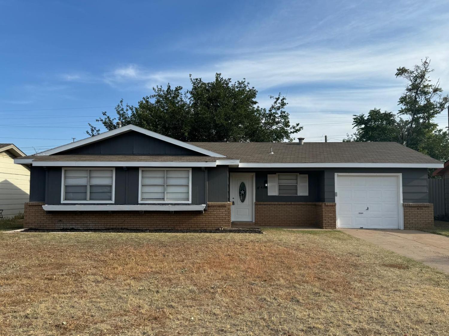 a front view of house with yard and trees