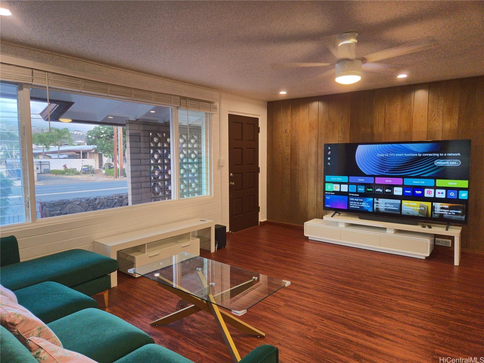 a living room with furniture a wooden floor and a large window