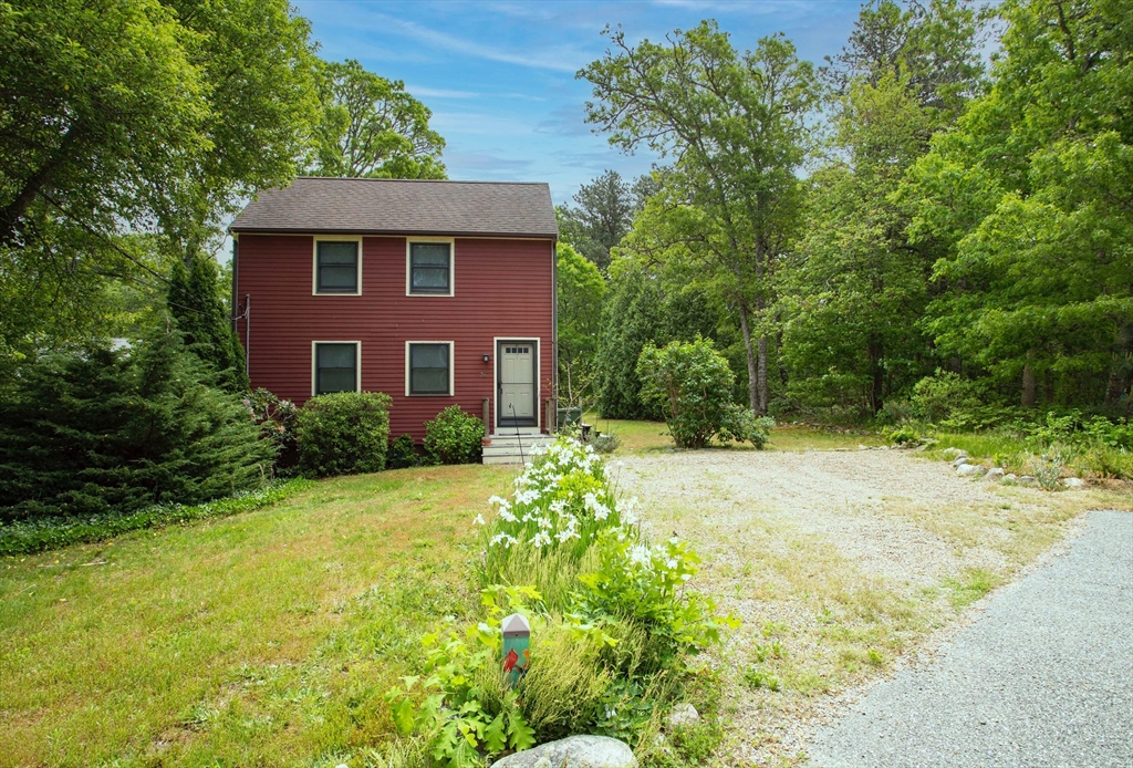 a view of a yard in front of a house with large trees