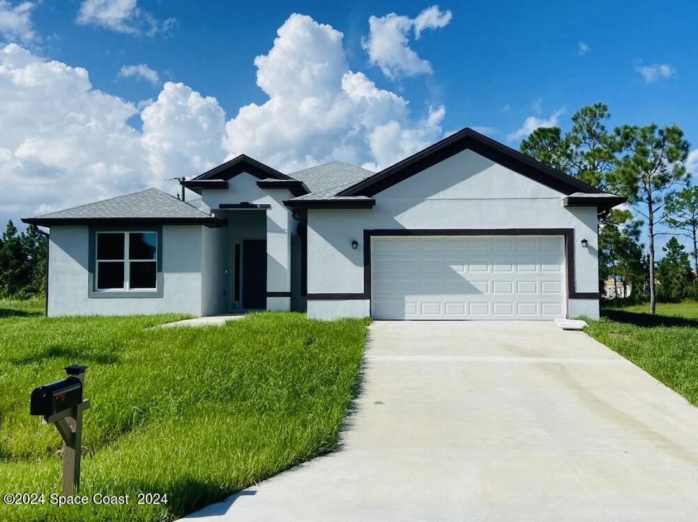 a front view of a house with a yard and garage