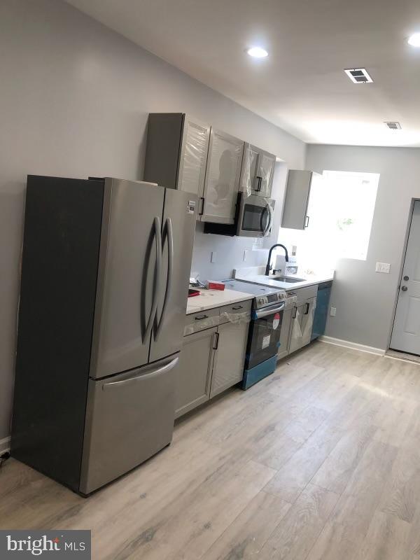 a kitchen with stainless steel appliances a refrigerator and a sink