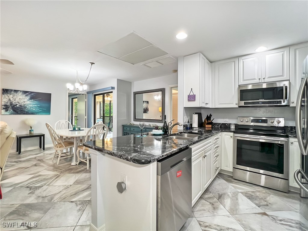 a kitchen with stainless steel appliances granite countertop a stove top oven a sink a dining table and chairs