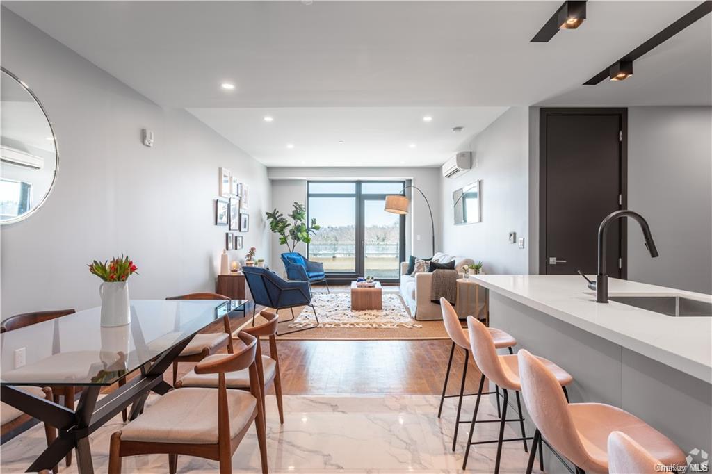 Dining area with an AC wall unit, sink, and light wood-type flooring