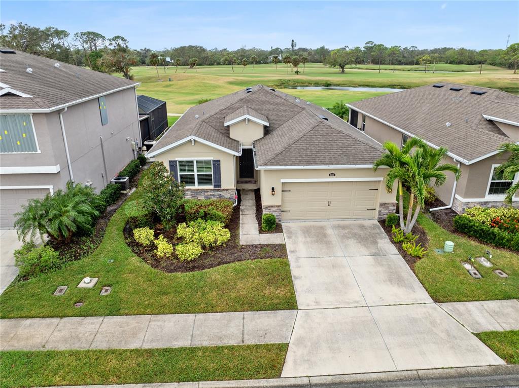 a aerial view of a house with outdoor space and a lake view in back