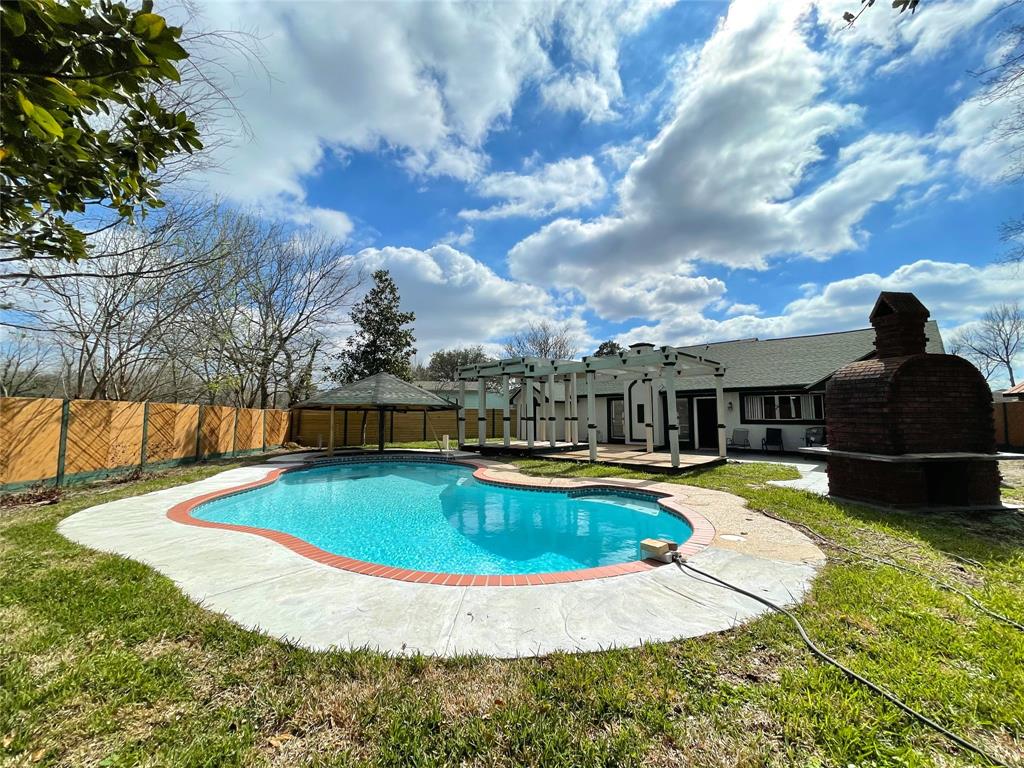 a view of a swimming pool with a yard and a fountain