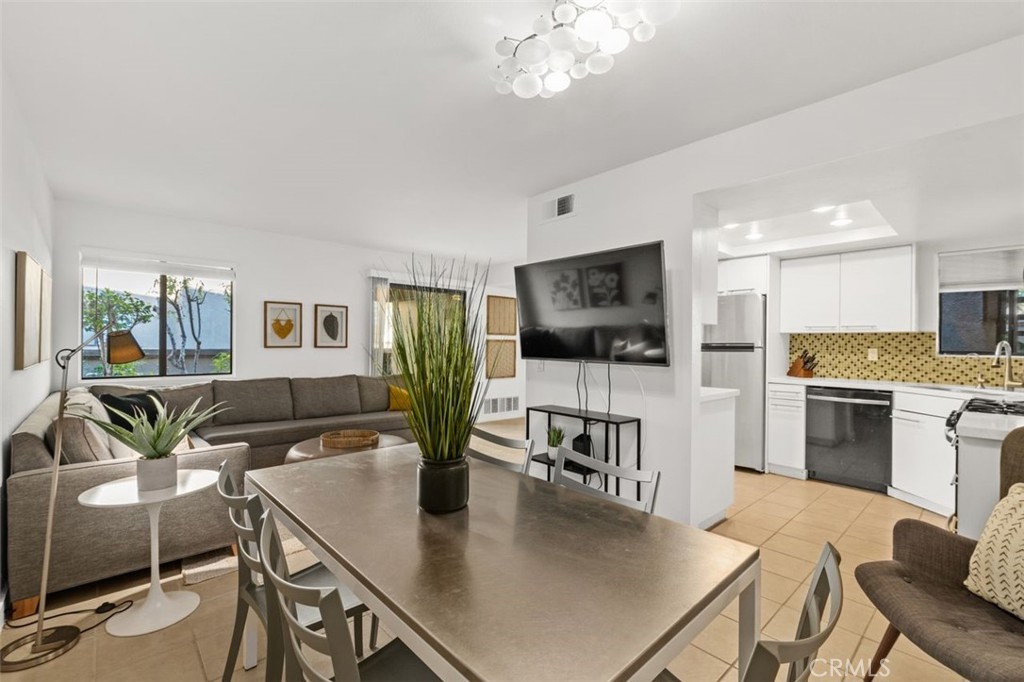 a living room with furniture kitchen view and a wooden floor