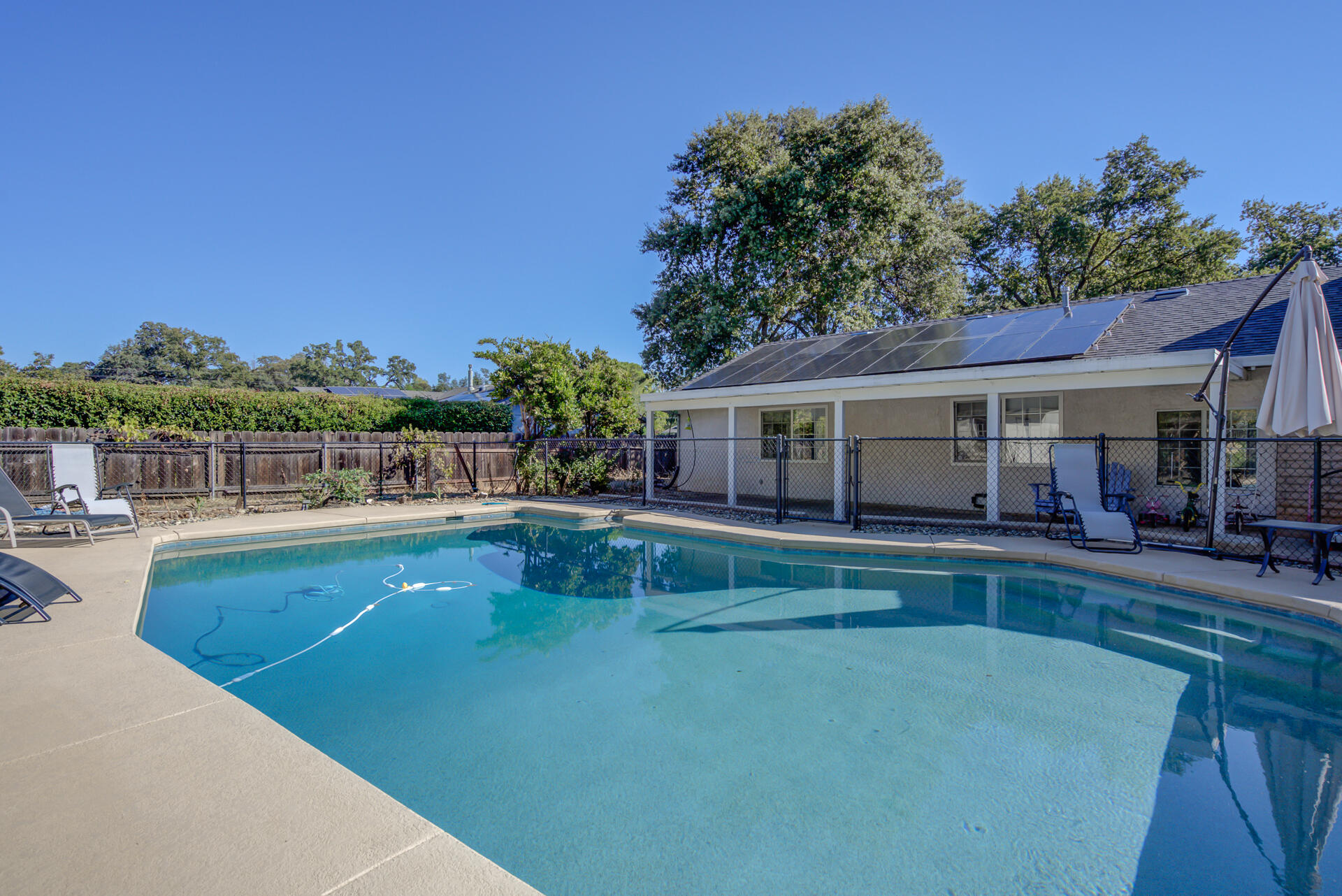 a view of house with swimming pool and outdoor seating