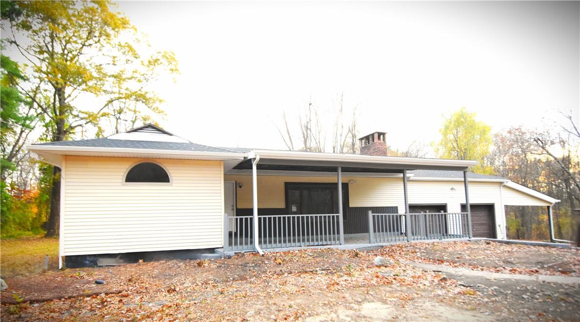 Back of house featuring a garage and a porch