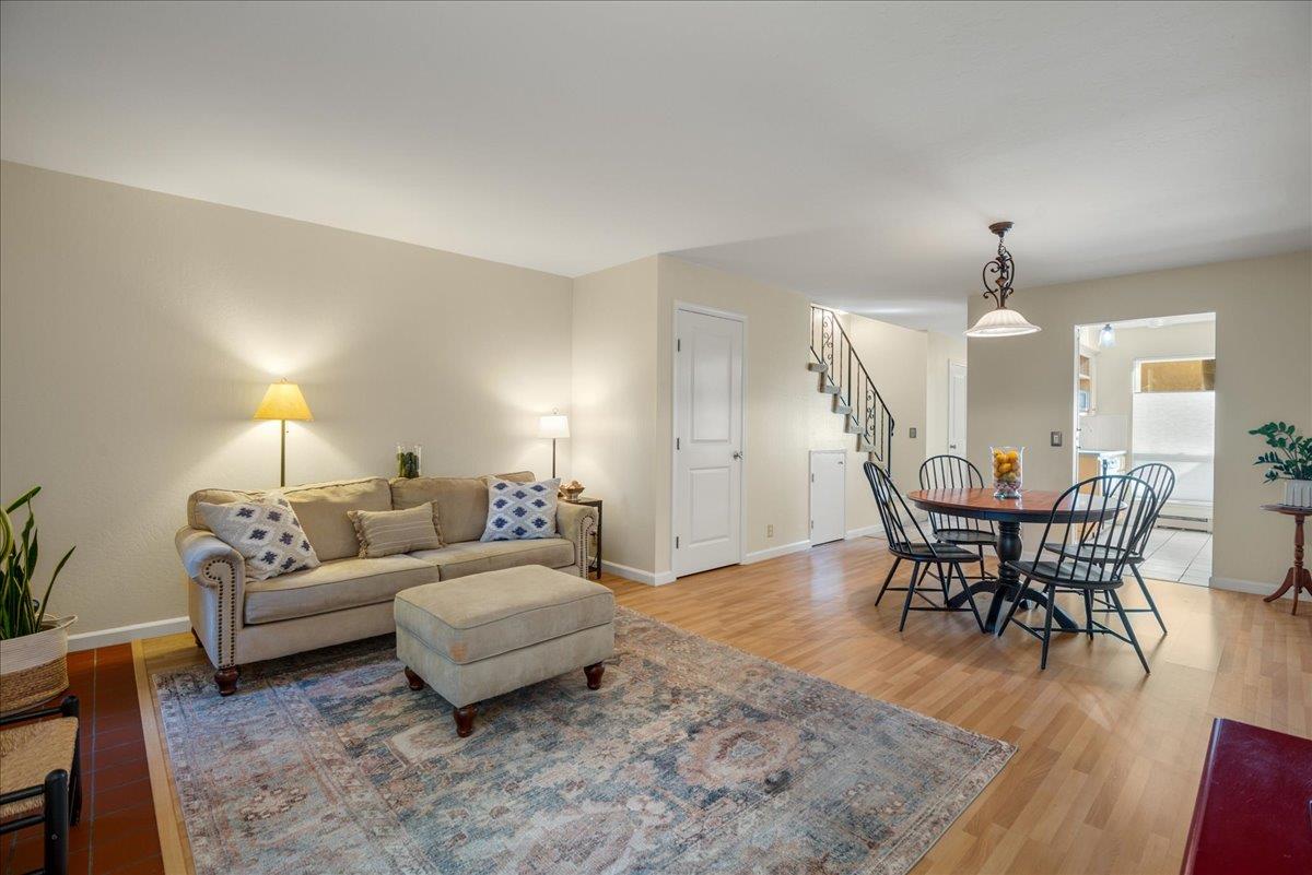 a living room with furniture a dining table and a potted plant